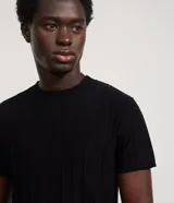 Remera slim de manga corta con cuello redondo, confeccionada en tejido de viscosa con textura de rayas verticales.