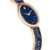 Reloj de pulsera con caja ovalada de 26 mm x 29 mm con acabado en tono oro rosa. Esfera azul iridiscente con marcadores de hora aplicados y logo de cisne de Swarovski a las 12. La corona tiene una piedra engastada. El brazalete es de metal ajustable y está decorado con aproximadamente 232 cristales Ultra Fine Crystal Rocks de color azul.