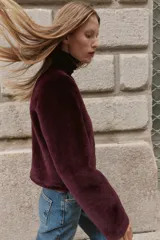 Chaqueta de cuello redondo y manga larga con tejido exterior efecto pelo e interior efecto ante. Presenta bolsillos delanteros de vivo y cierre frontal con alamares metálicos.