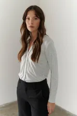 Remera manga larga color borgoña con cuello en V y costuras decorativas verticales.