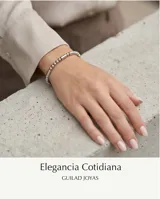 Pulsera tipo esclava de acero, compuesta por una combinación de esferas pequeñas y cilindros alargados en tono plateado.