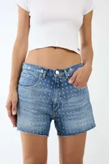 Short de denim azul con tachas plateadas, tiro alto y ruedo desflecado.