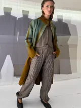 Pantalón babucha de lana color gris con textura en las piernas y elástico con broches en los tobillos.