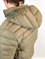 Campera puffer verde oliva de nylon con capucha desmontable y bolsillos laterales.