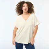 Camiseta de tejido crepé color beige, con escote en V y mangas cortas con dobladillo.