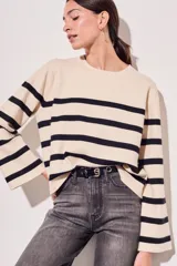 Sweater de punto con diseño a rayas horizontales en color crema y marrón, de corte holgado, cuello redondo y mangas largas acampanadas.