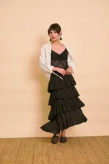 Pollera midi negra de corte acampanado con múltiples volantes escalonados y cintura elástica.