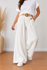 Pantalón palazzo tiro alto color blanco de United Uy, confeccionado en viscosa con cintura elástica y bolsillos laterales. Incluye un cinto trenzado con hebilla redonda de carey.