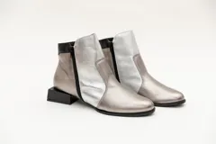 Botín de cuero negro con apliques dorados, punta almendrada, cierre lateral y taco cuadrado.