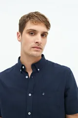 Camisa de manga corta confeccionada en una mezcla de lino y algodón, con cuello clásico, cierre frontal de botones y bolsillo en el pecho con logo bordado.