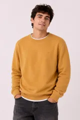 Buzo deportivo gris melange con cuello redondo, mangas largas y puños elásticos acanalados. Cuenta con un pequeño logo bordado en el pecho.