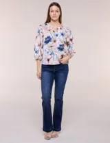 Blusa de gasa liviana blanca con estampado floral en tonos azules y rosados, escote en V, mangas 3/4 abullonadas con puños elásticos y corte fluido.
