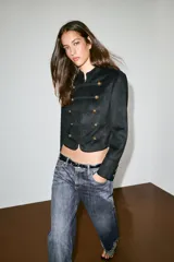 Jeans de mezclilla de tiro bajo con diseño de cinco bolsillos, trabillas para cinturón y bajo con vuelta marcada. Cierre frontal con cremallera y botón metálico.