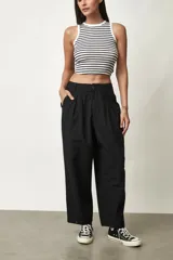Pantalón negro de tiro alto y corte amplio, con pinzas en la cintura y bolsillos laterales.