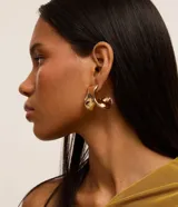 Aros dorados de metal con forma orgánica y cierre de tornillo.