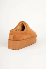 Zueco de gamuza color beige con interior forrado en piel sintética y plataforma de 5 cm de altura.