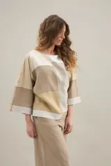 Blusa de diseño patchwork en tonos beige, blanco y tostado, confeccionada con recortes de lino y algodón, cuello redondo, mangas cortas y calce relajado.