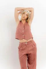 Chaleco de lino color bordó con escote en V y cierre frontal de botones. Presenta costuras a contratono y un diseño liviano ideal para el verano.