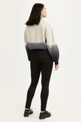 Jean de corte super skinny, tiro medio y color negro sólido. Presenta un diseño clásico de cinco bolsillos con cierre de cremallera y botón metálico.