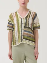 Sweater de crochet modelo Lenka confeccionado en mezcla de algodón orgánico, acrílico y lino orgánico. Presenta un diseño multicolor con franjas verticales y horizontales, cuello camisero, mangas cortas y cierre frontal de botones.