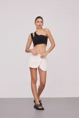 Top corto blanco de algodón, con un solo hombro y corte asimétrico.