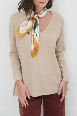 Sweater de tejido de punto color beige, con escote en V y mangas largas. Presenta un diseño básico y versátil de corte recto.