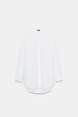 Camisa de corte oversize con cuello solapa, manga larga con puños y bajo asimétrico. Cierre frontal con botones.