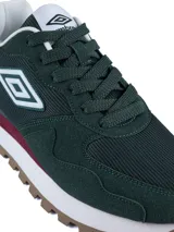 Championes urbanos Umbro de diseño deportivo, confeccionados en una combinación de gamuza y malla en tonos beige y gris claro. Presentan el logo de la marca en el lateral, una entresuela blanca con refuerzo azul oscuro en el talón y una suela dentada en color marrón.
