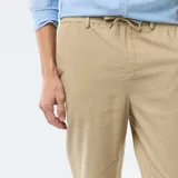 Pantalón chino regular de lino mezclado en color beige, con bolsillos laterales y cierre de botón y cremallera.