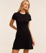 Vestido corto color ladrillo, confeccionado en tejido de punto rib de algodón y elastano. Tiene cuello redondo y mangas cortas.