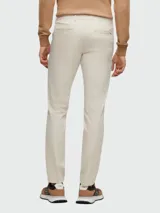 Pantalón de vestir color beige, corte slim fit, con bolsillos laterales y traseros.