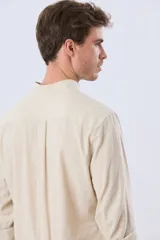 Camisa de lino y algodón color blanco, con cuello mao, manga larga y medio cierre frontal con botones.
