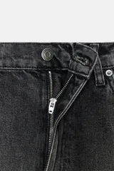 Jeans de tiro bajo con corte baggy y ajuste holgado. Presentan diseño de cinco bolsillos, cierre frontal con cremallera y botón metálico, y trabillas en la cintura.