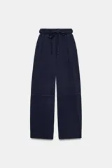 Pantalón de tiro alto con tejido principal confeccionado en hilatura de algodón 100%. Bolsillos en delantero. Cintura ajustable con cordones combinados a tono.