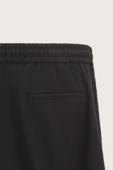 Pantalón regular fit color negro de tejido con viscosa, con cintura elástica ajustable con cordón, bolsillos frontales y traseros.