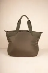 Bolso tipo shopper color beige, con asas fijas superiores y correa desmontable y regulable. Cuenta con dos bolsillos externos y tres bolsillos internos.