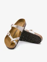 Sandalias Birkenstock modelo Mayari, color blanco aperlado, con dos tiras delgadas ajustables con hebilla metálica y plantilla anatómica de corcho y látex.