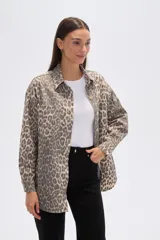 Chaqueta de algodón con estampado de leopardo en tonos grises y beige, corte ancho tipo camisa (shacket), con cuello camisero, botones frontales y bolsillos de parche en el pecho.