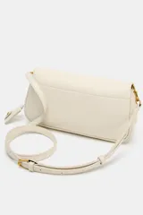 Bolso bandolera alargado de color blanco marfil con solapa redondeada y detalle metálico dorado. Incluye doble asa bandolera ajustable, una de ellas en tejido.