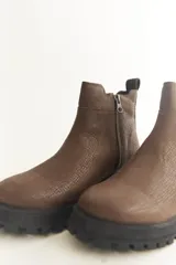 Botas Chelsea negras de cuero con elástico lateral, suela track y tirador trasero.