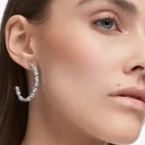 Aros tipo argolla Swarovski Mesmera bañados en rodio con circonias blancas de diferentes tallas engarzadas en garra. Cierre con perno.