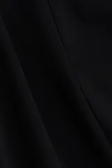 Top de manga larga confeccionado en punto de crepé, con cuello redondo y diseño de peplum. Presenta costuras moldeadoras en la parte frontal y posterior que definen la silueta.