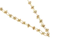 Cadena dorada de acero con eslabones tipo rolo y eslabones con nudo.