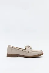 Zapato náutico de símil cuero color beige, con cordones frontales, costuras a la vista y suela plana antideslizante en tono marrón.