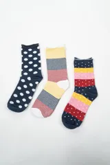 Pack de tres pares de medias de caña media con diseños estampados: un par azul marino con lunares blancos, un par a rayas horizontales en amarillo, azul y rojo, y un par azul marino con rayas horizontales en rosa, amarillo y rojo con lunares blancos.