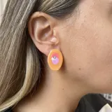 Par de aros con forma ovalada irregular, color verde lima con detalles en rosa y aplique de strass.