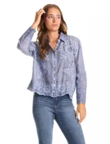 Camisa de manga larga confeccionada en algodón con delicados bordados florales en toda la prenda. Presenta cuello clásico con solapa, cierre frontal con botones y un corte holgado.