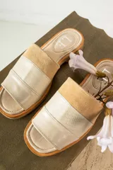 Sandalias tipo chinela de cuero, con diseño de banda ancha que combina cuero liso, cuero texturizado y gamuza en tonos marrones. Presenta plantilla con logo grabado.