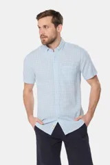 Camisa de lino de manga corta con estampado a cuadros en tonos celestes y blancos, cuello con botones y bolsillo ojal en el pecho.