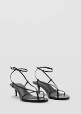 Sandalias de tacón bajo fino con diseño de tiras finas y cierre ajustable al tobillo con hebilla metálica.